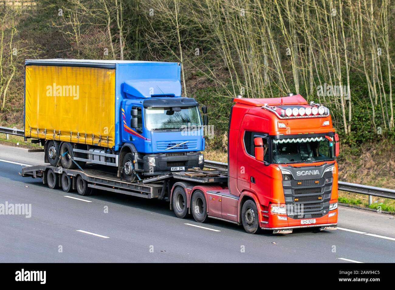 HGV breakdown recovery; heavy bulk Haulage delivery trucks, Scania haulage, DAF lorry on Scania trailer,  transportation, truck, cargo, vehicle delivery, transport industry recovery vehicles on the M61 at Manchester, UK Stock Photo