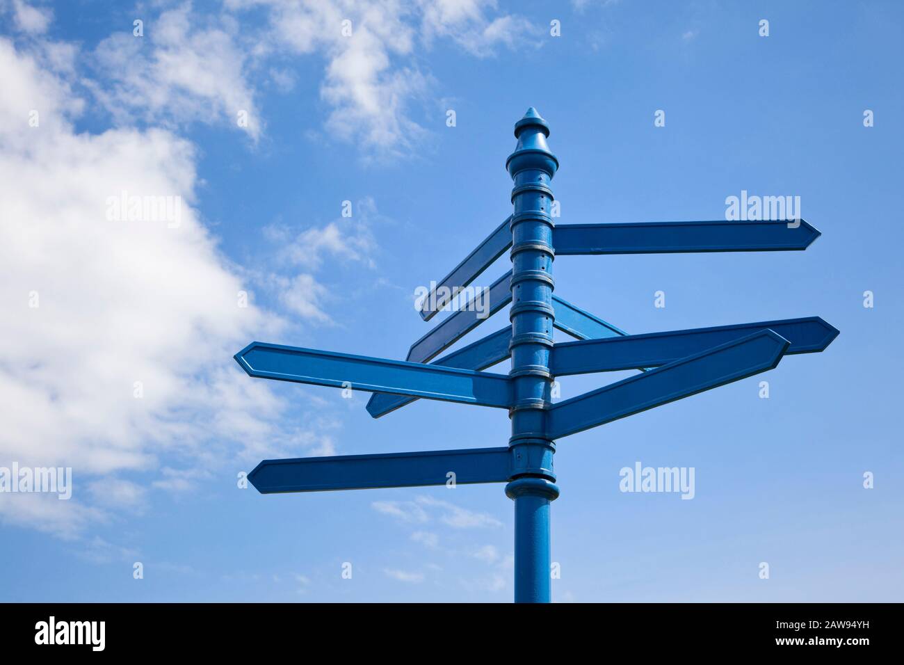 Blank signpost multiple directions against a blue sky Stock Photo