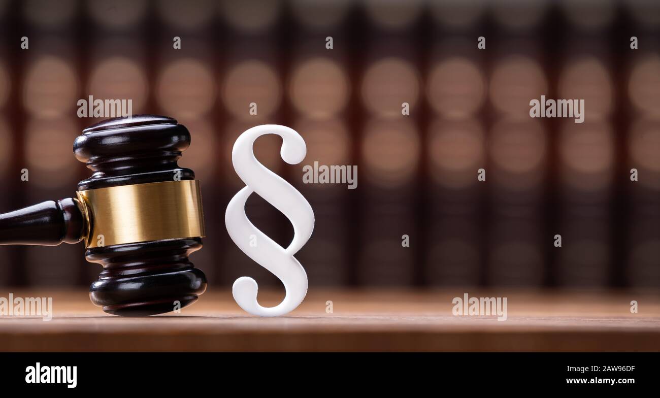 Gavel And Paragraph Sign On Wooden Desk Stock Photo