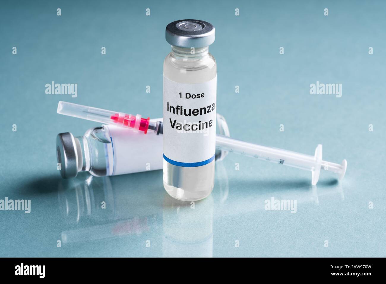 Influenza Flu Vaccine Vials With Syringe Over Turquoise Background Stock Photo