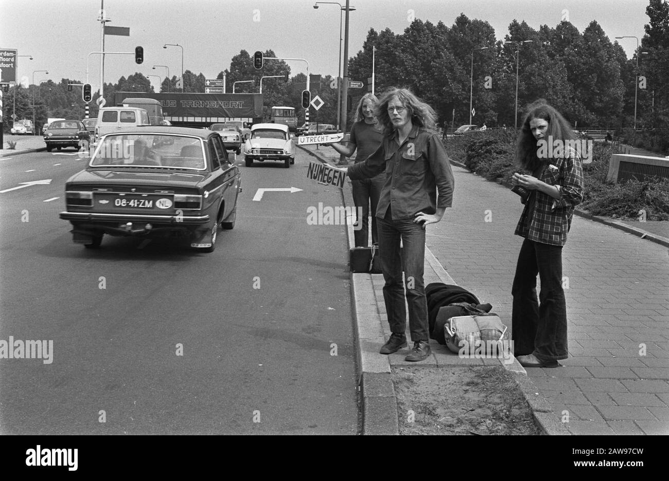 Holiday Bustle begun description: Hitchhikers roadside Date: July 10, 1975 Keywords: luggage, youth lifters, travel, vacation Stock Photo