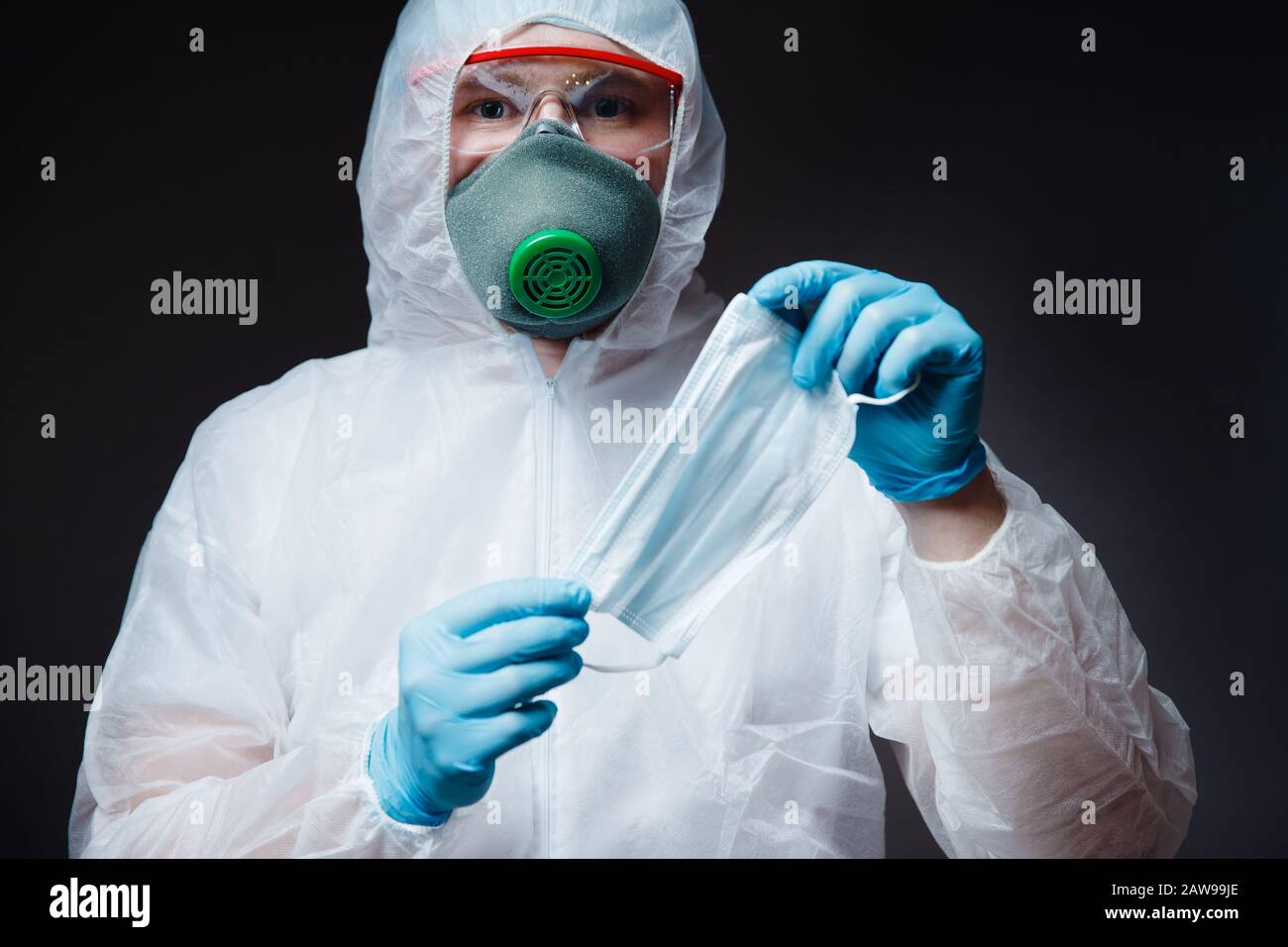 Medic man in white hazmat protective holding gauze bandage mask for ...