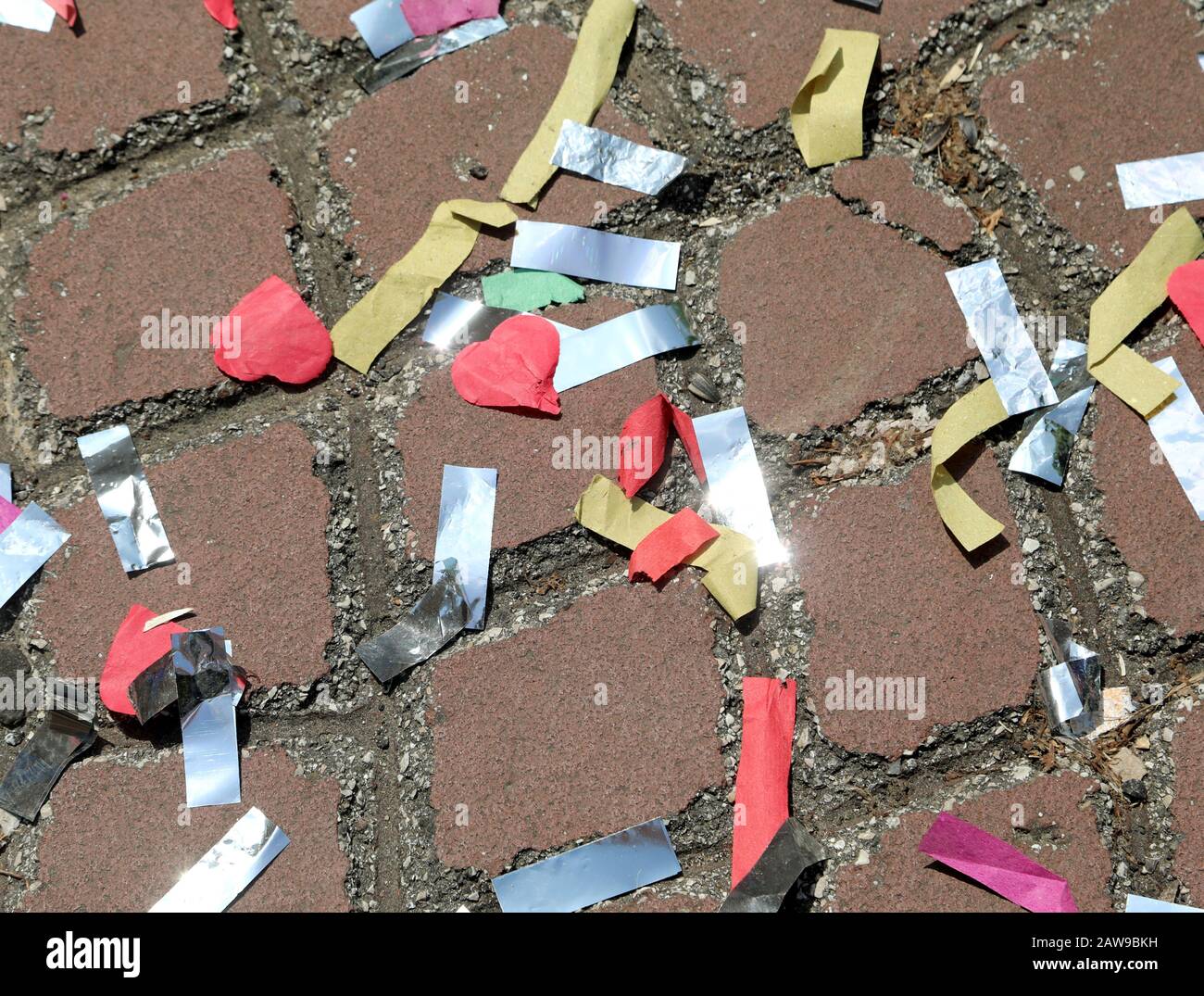 many colorful confetti scattered on the asphalt after a Carnival parade ...