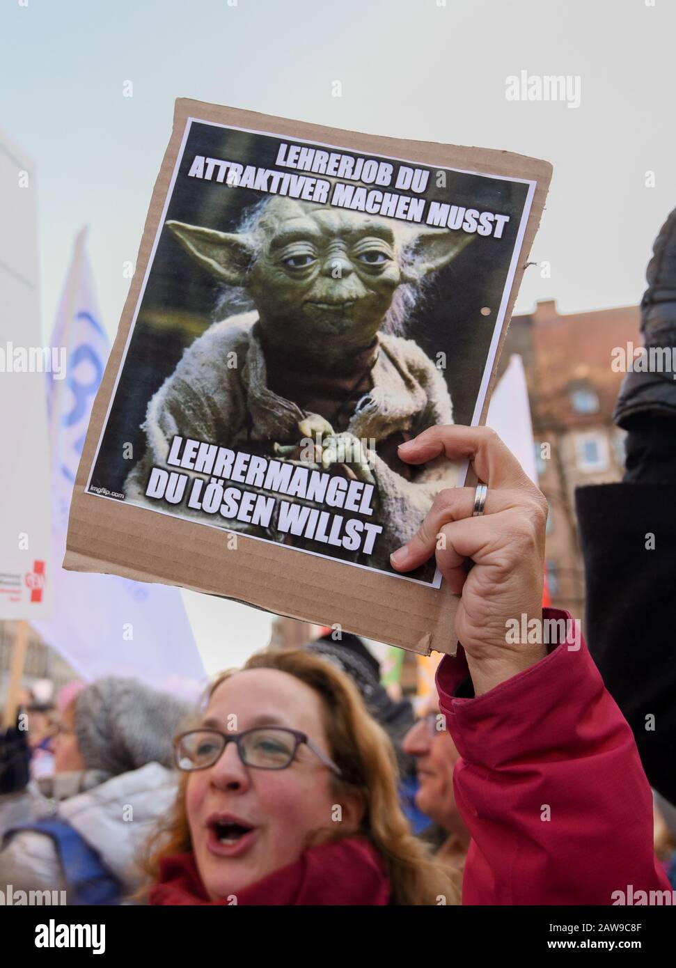 Nuremberg, Germany. 07th Feb, 2020. During a demonstration, a woman holds a sign with the Star Wars character Yoda and the inscription 'Teacher job you must make more attractive. teacher shortage you want to solve'. The GEW union and the Bavarian Teachers' Association (BLLV) held a rally against the Bavarian Ministry of Education's package of measures to combat the shortage of teachers. Credit: Nicolas Armer/dpa/Alamy Live News Stock Photo