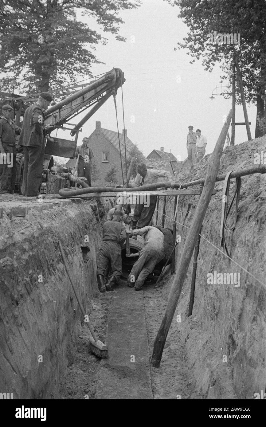 normalization of streams, digging and filling in trenches, laying drains, culverts, hedge, workers, sewer pipes, cars Date: August 1951 Location: Oss Keywords: workers , cars, hedge, culverts, digging and filling in trenches, laying drains, normalization of streams, sewers Stock Photo