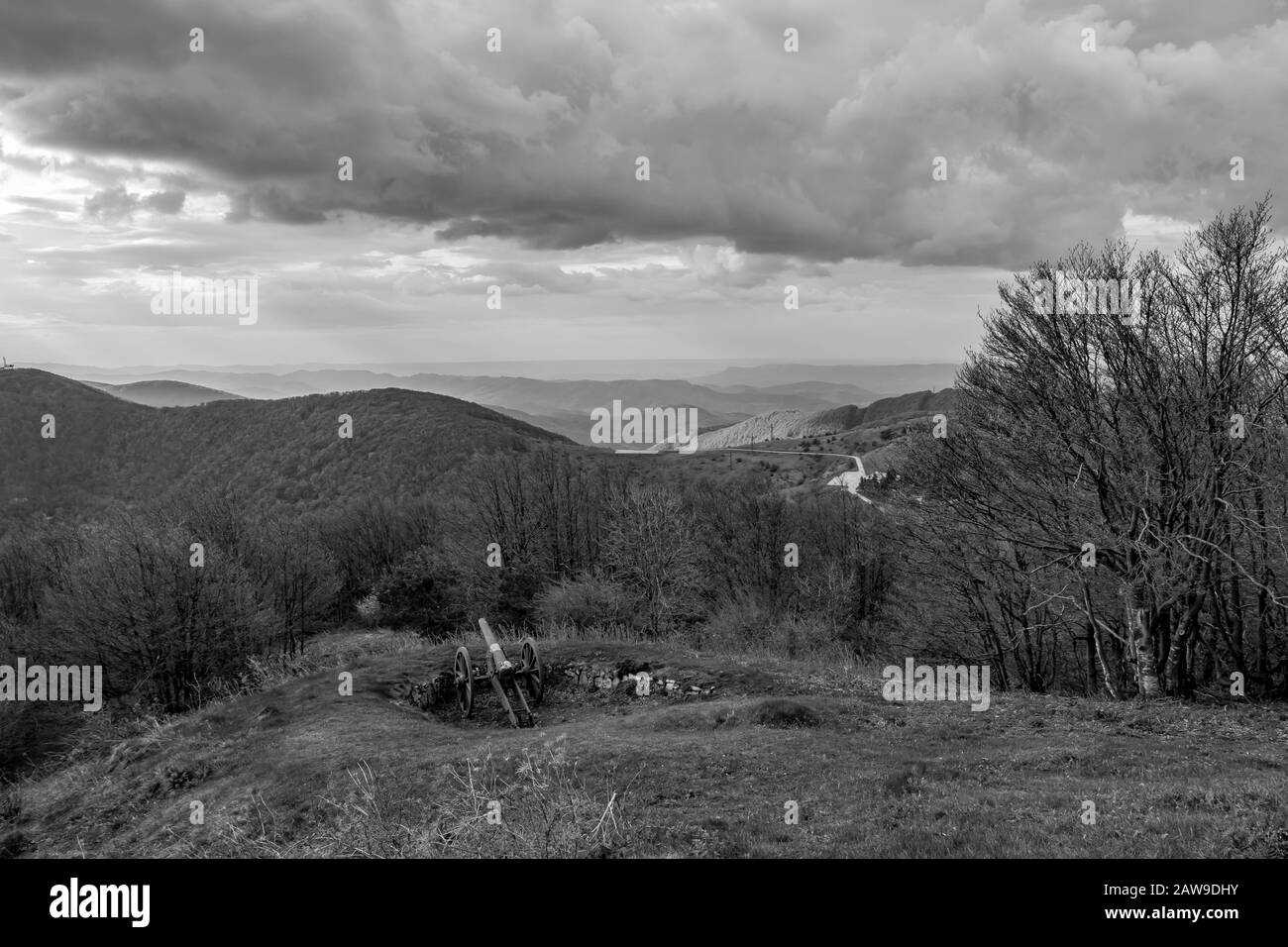 Dramatic autumn black and white view over the mountain range from near Shipka peak, Stara Planina mountain in Central Bulgaria as seen from Shipka Memorial. Moody feeling. Old Russian cannon Stock Photo
