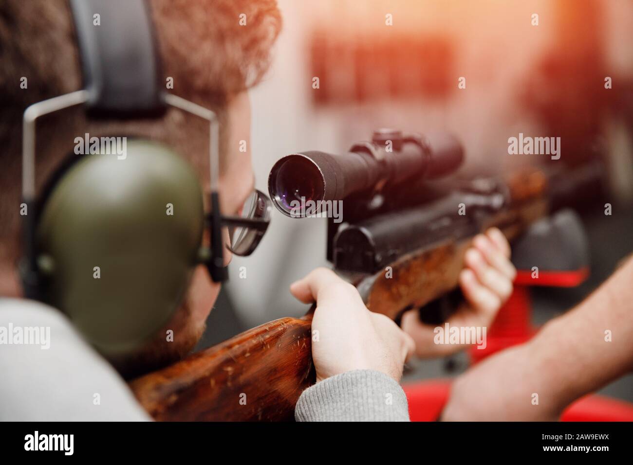 Shooting range gun. Man shoots pistol in noise protection headphones