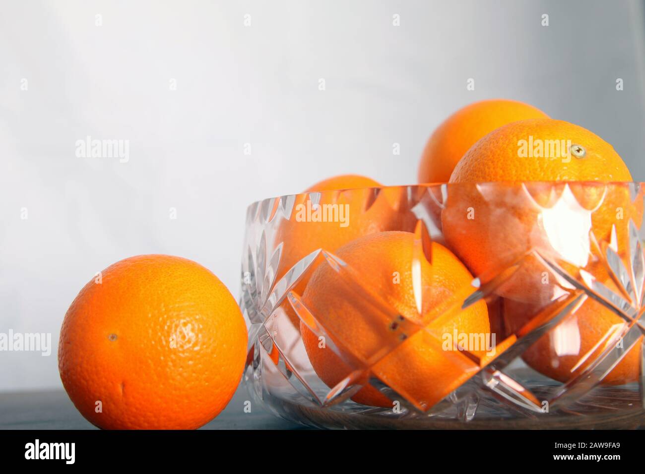 Lead crystal fruit bowl full of oranges 'fruit' against white background with copy space Stock Photo
