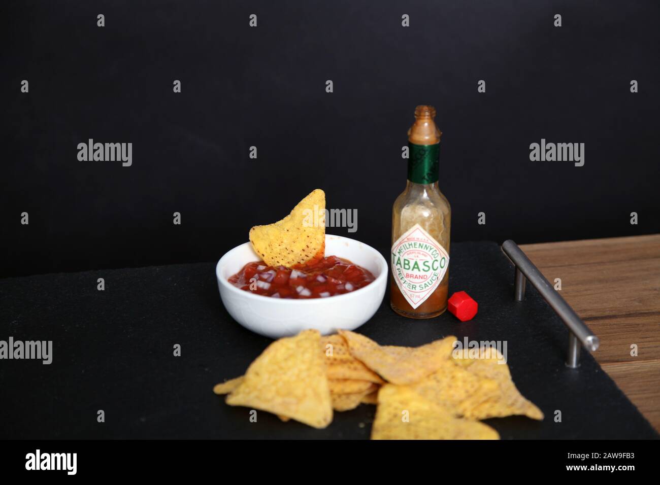 Hot Salsa dip with Doritos tortilla chips and Tabasco Sauce against ...