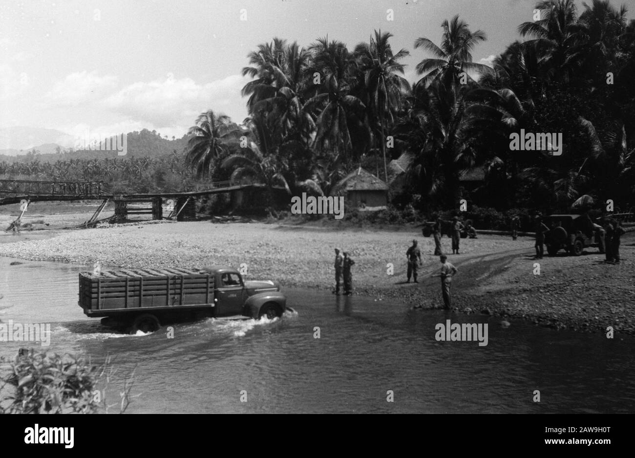 march to Fort van der Capellen and Fort de Kock (Anei Gorge)  [Army truck crosses a river at a ford over. In the background a destroyed bridge on which a bailey bridge is] Date: December 29, 1948 Location: Bukittinggi, Indonesia, Dutch East Indies, Sumatra Stock Photo