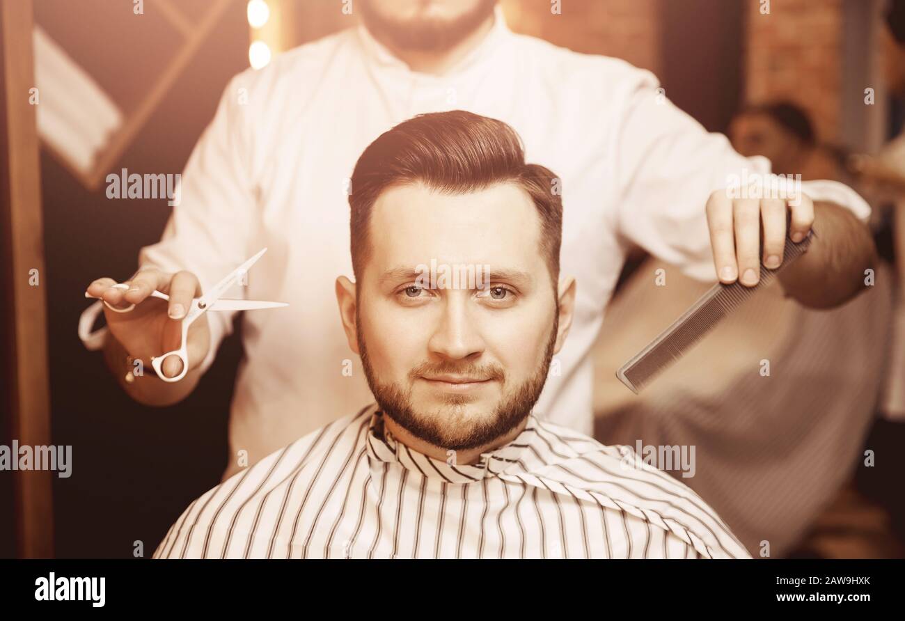 Man with beard in barber shop. Modern hair salon Stock