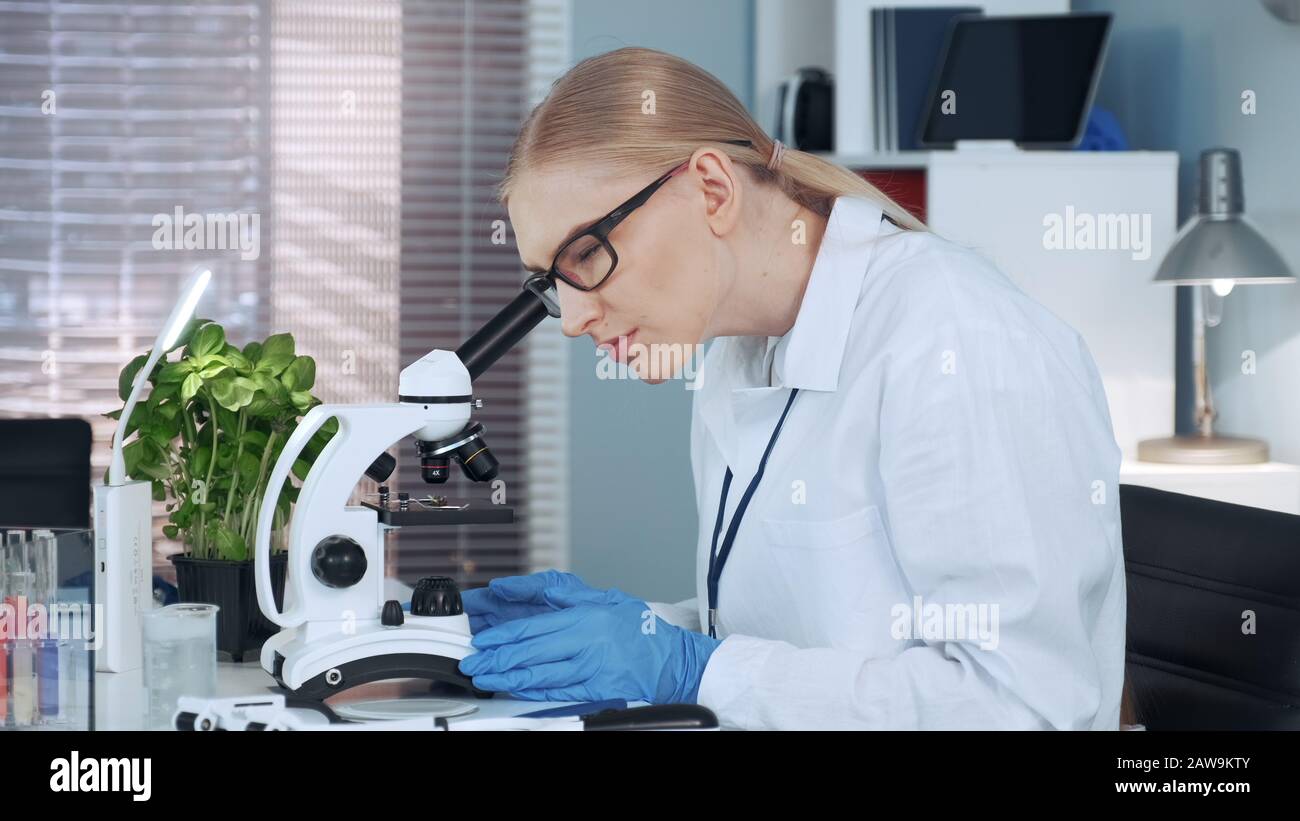 Female chemistry professor using tweezers to put organic material on ...