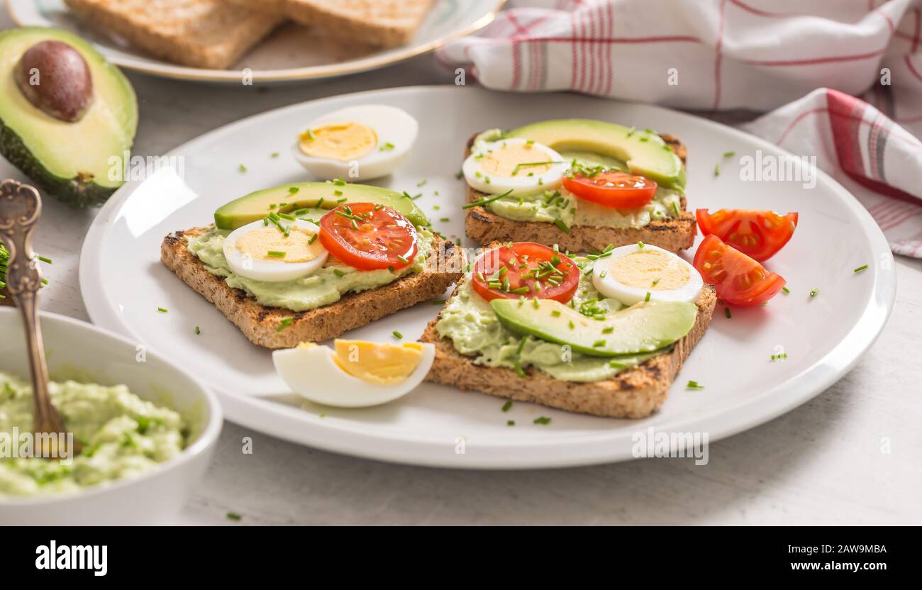 Healthy breakfast from toasts with avocado spread guacamole egg tomato