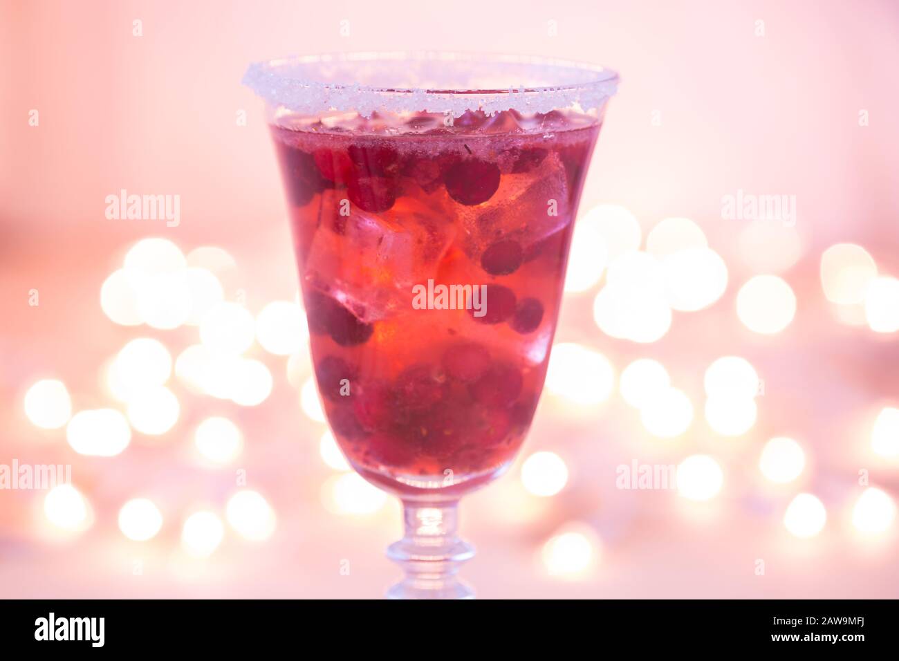 Glass of champagne and cranberry cocktail, macro. Lightweight background. Christmas mood. Vintage style. Shifted white balance, pink tone. Horizontal Stock Photo