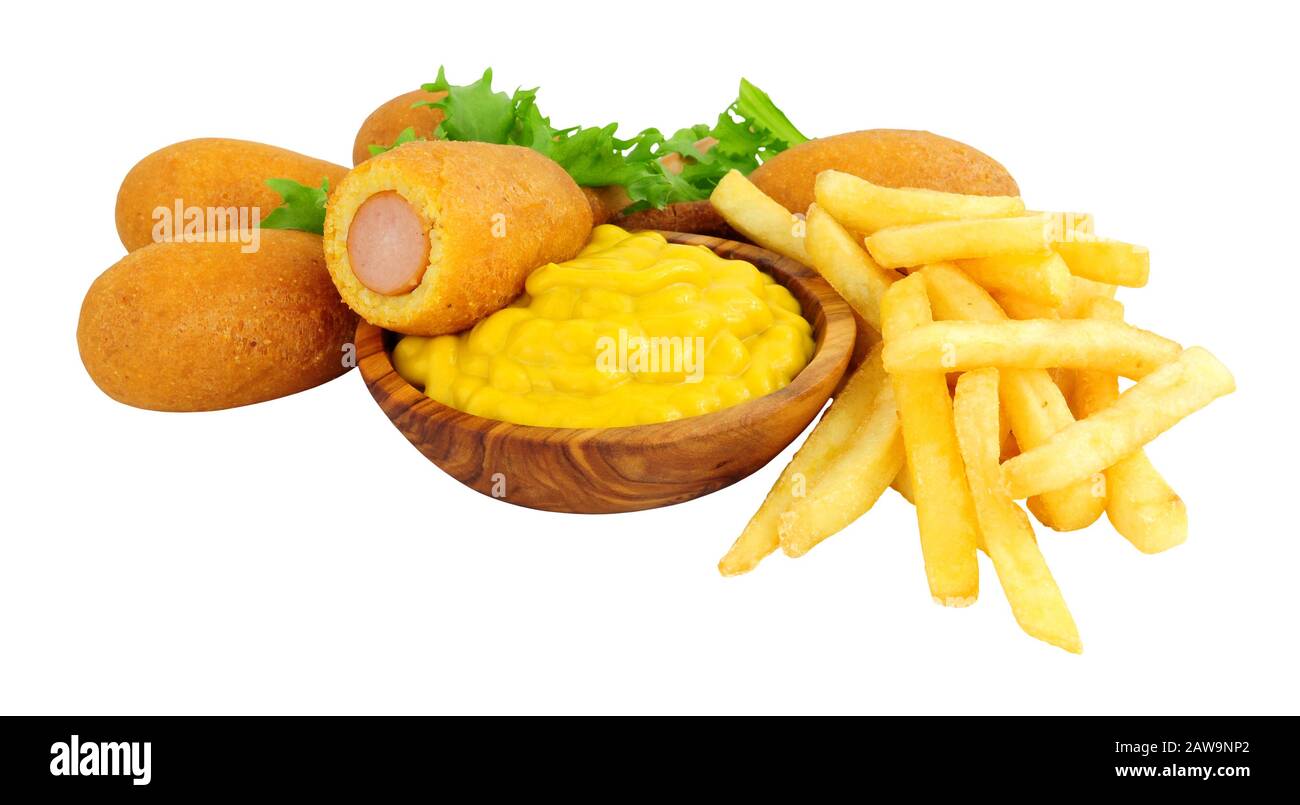 Mini party corn dogs on wooden sticks and French fries with a wooden bowl of American mustard isolated on a white background Stock Photo