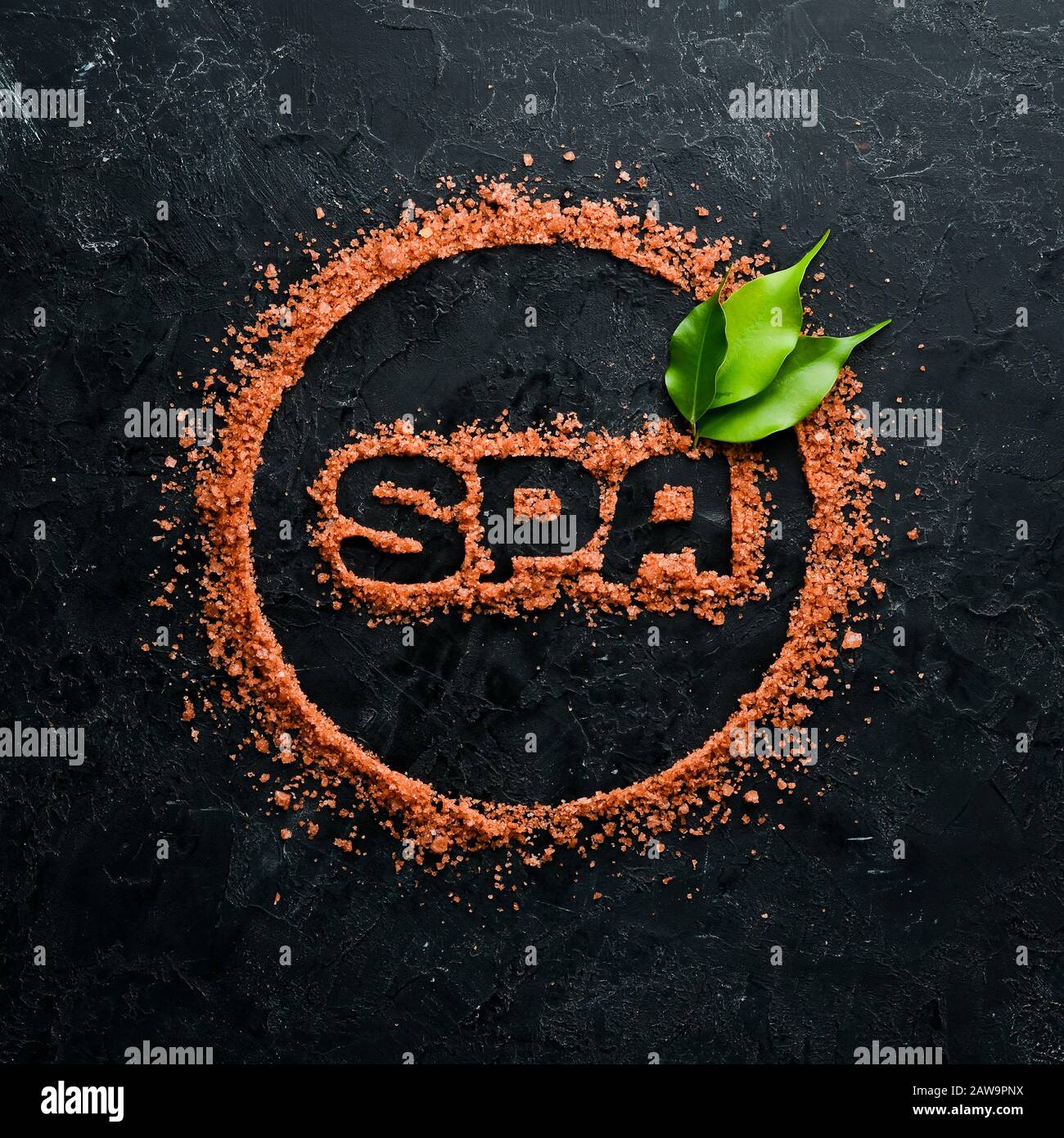 Brown Sea salt with SPA inscription. On a black stone background. Spa ...