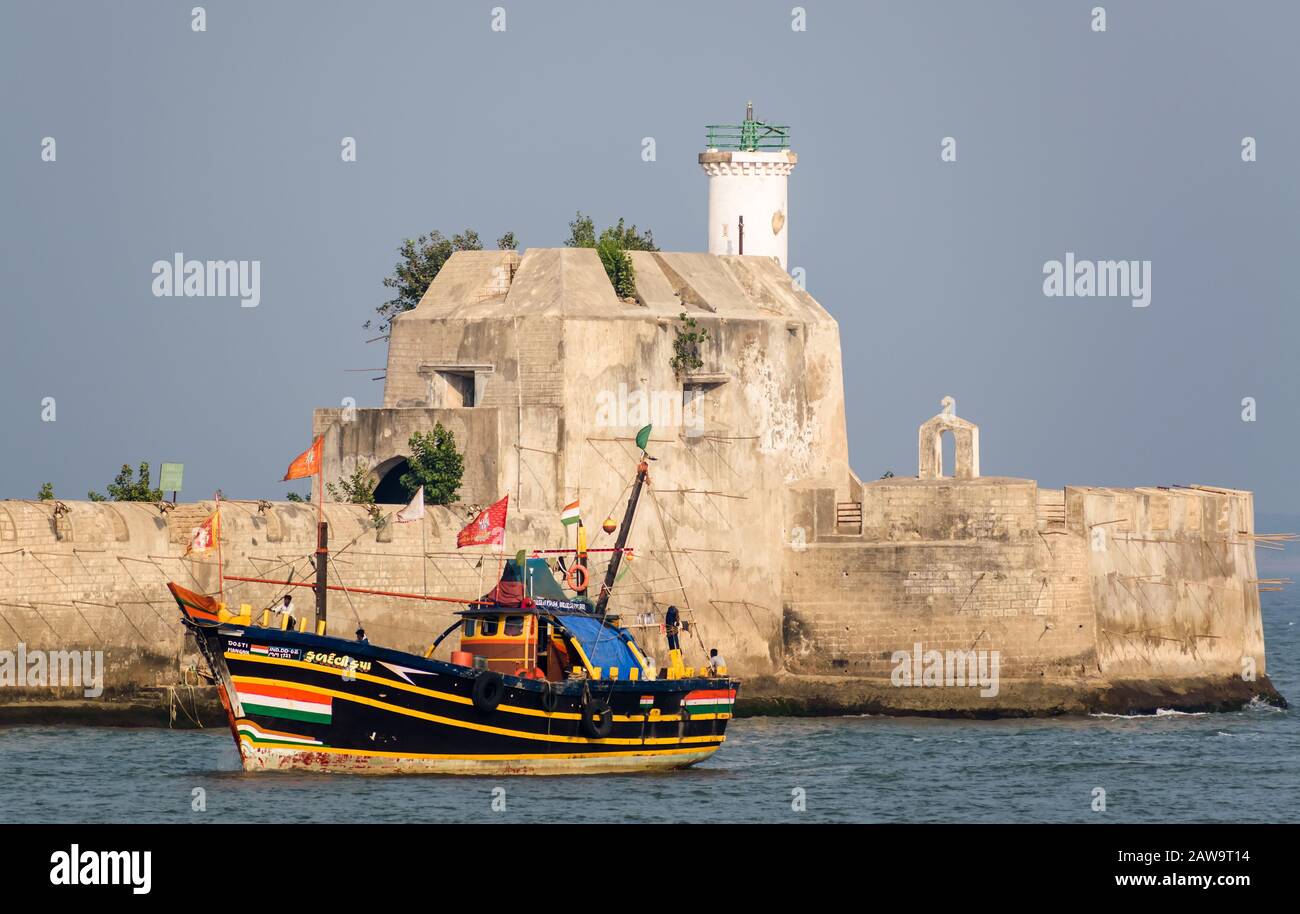 A colorful fishing boat goes past the Pani Kotha aka Fortim De Mar, the island fortress and prison in the middle of the sea off the island of Diu. Stock Photo