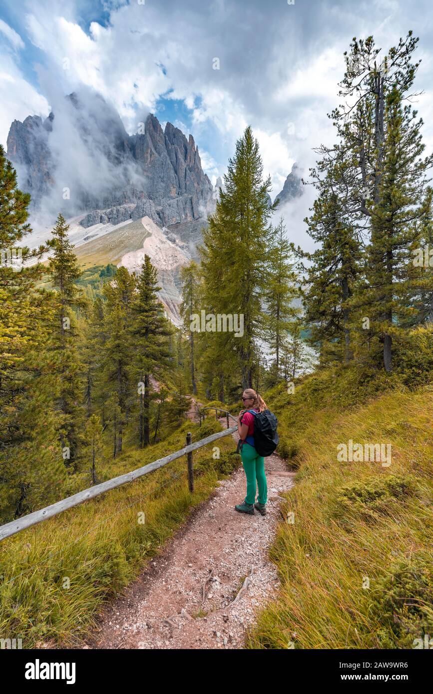 Young woman, hiker on a hiking trail, in the back Sass Rigais, Parco Naturale Puez Odle, South Tyrol, Italy Stock Photo