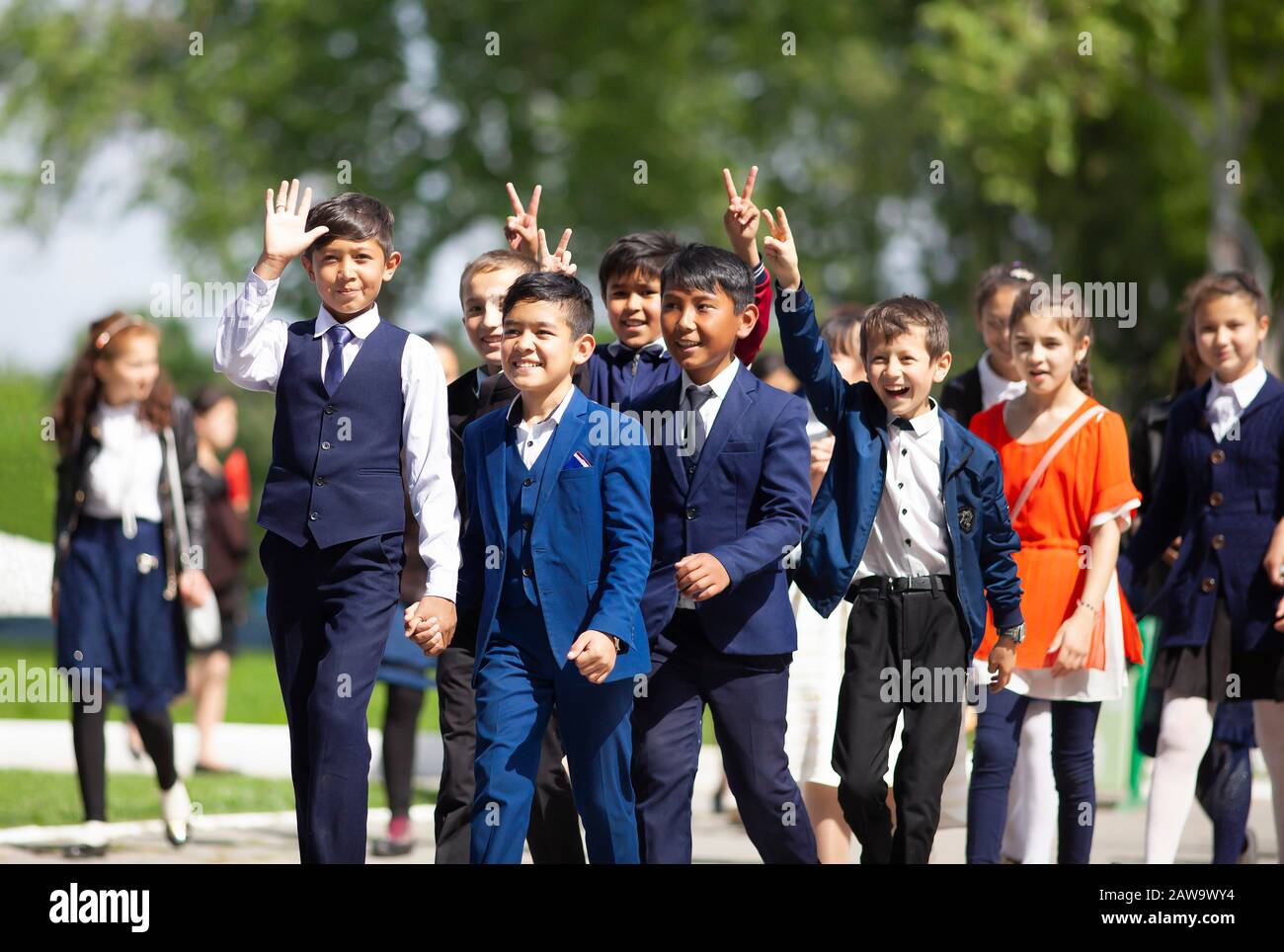 Happy students in evening dress on the university boulevard, Samarkand, Samarqand Province, Uzbekistan Stock Photo