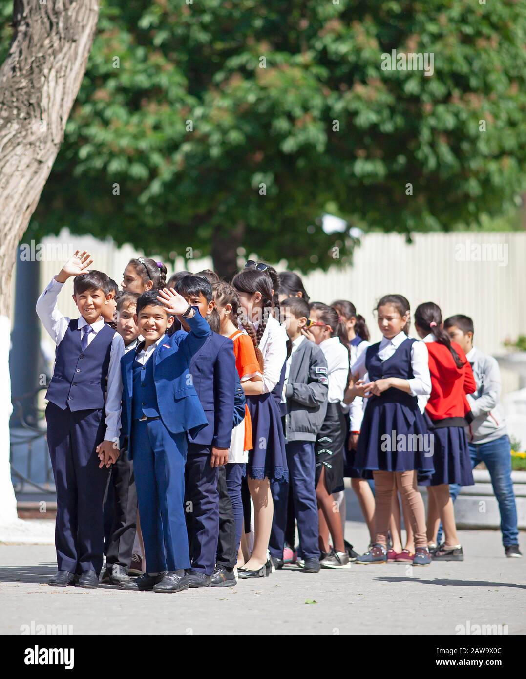 Happy students in evening dress on the university boulevard, Samarkand, Samarqand Province, Uzbekistan Stock Photo
