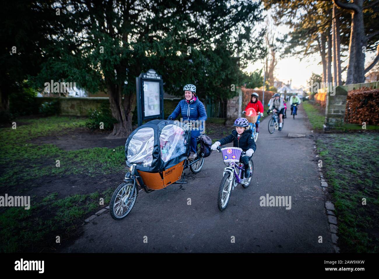 Edinburgh, Scotland. 7 February 2020. Participants at the Corstorphine Bike Bus cycle to school on a winter’s morning in Edinburgh. Bike buses are a group ride to school along a pre-planned route. The group is organised by Ride Leaders and experienced cyclists and will move at a slow, controlled speed, along roads and traffic-free paths. The Corstorphine Bike Bus is organised by members of the Corstorphine Primary School Travel Action Group, part of the Parent Council. It takes place on the first Friday of every month. Stock Photo