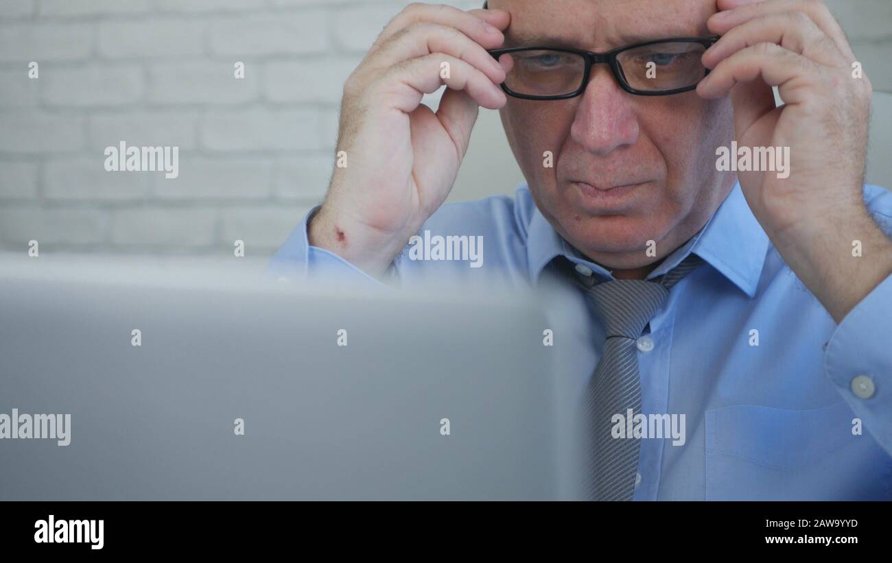 Serious Businessman in Office Room Using a Laptop, Businessperson Managing Company Information Stock Photo