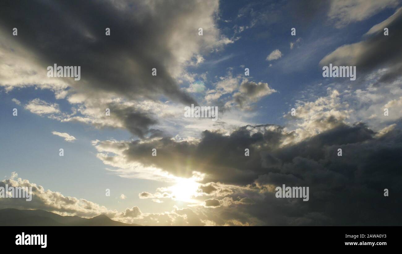 Stormy clouds with sun shining. Dramatic rain clouds. Stock Photo