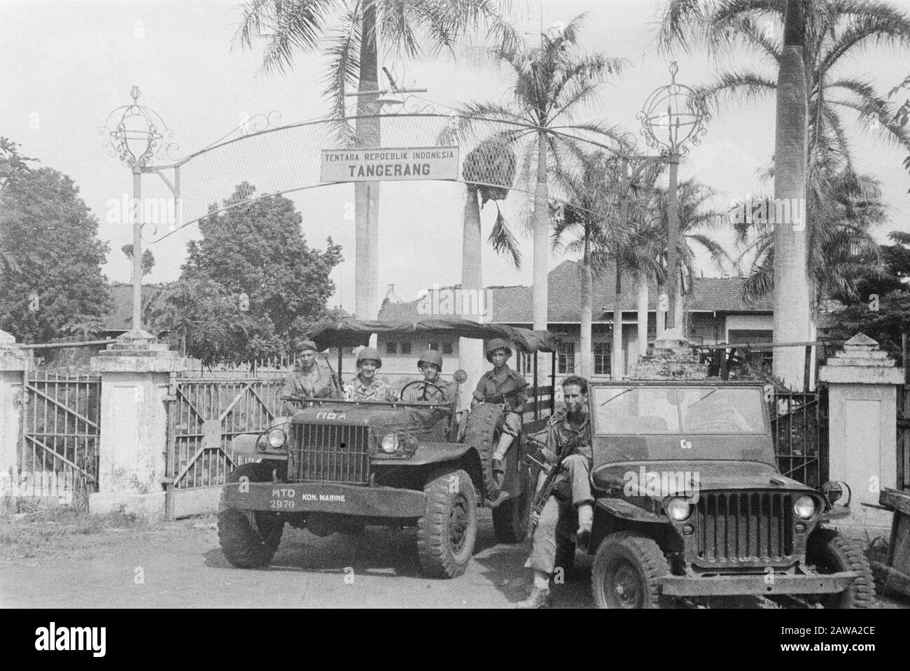 Assignment Tangerang  [Dutch millitairen (marines?) In jeeps under a gate that says Tentara Republik Indonesia Tangerang] Annotation: The Jeep is the Marine Brigade . But operated mainly in Eastern Java.Tot Mar was there encamped part of 1Bat in Batavia. Date: May 28, 1946 Location: Indonesia Dutch East Indies Stock Photo