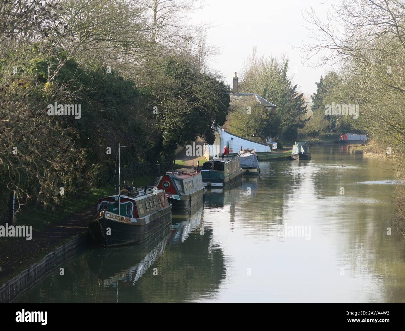 Narrowboats on a sunny winter's day moored along the banks of the Grand Union Canal in Northamptonshire. Stock Photo