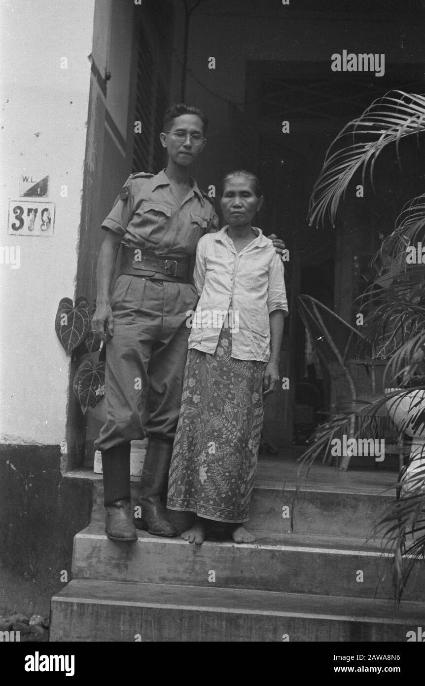 Gombong description: Man with glasses in KNIL uniform with older woman (his mother?) Annotation: Waarchijnlijk of KNIL infantry V (Andjing Nica) stationed around Gombong. His sleeve emblem is unclear Date: September 1947 Location: Indonesia Dutch East Indies Stock Photo