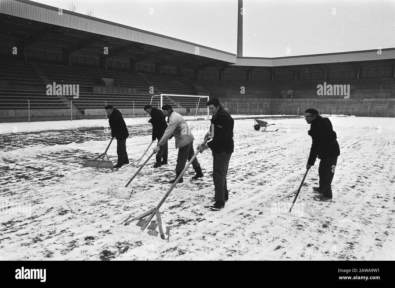 PSV stadium is snow cleared for football match against description: Men with snow blades Date: March 8, 1971 Location: Eindhoven, Noord-Brabant Keywords: snow, sports stadiums, football Institution Name: Vorwarts Berlin Stock Photo