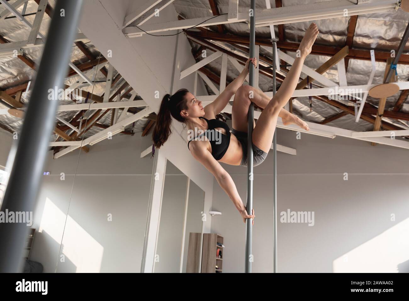 Caucasian woman pole dancing Stock Photo