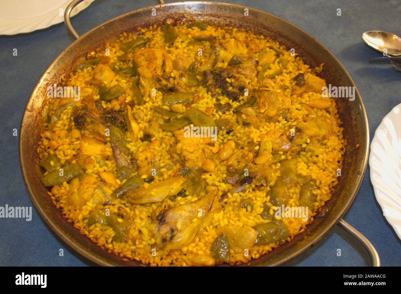 Close-up of a traditional Valencian paella on a table ready to be served on the plates to eat Stock Photo