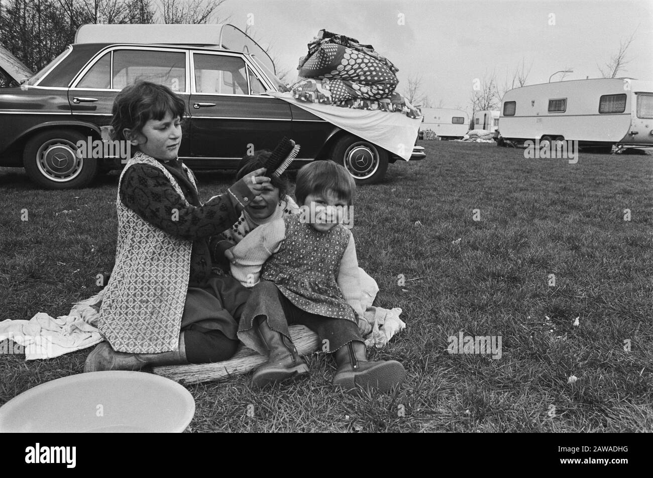 Gypsies of the Romanov family installed a camp site in Lelystad  Girls make each toilet Date: March 3, 1977 Location: Flevoland, Lelystad Keywords: Roma and Sinti, cars, kids Stock Photo