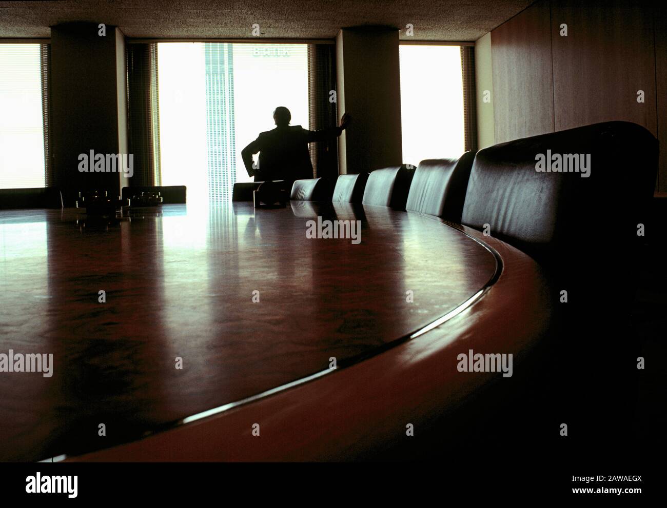 Executive looks out of a boardroom window. Stock Photo