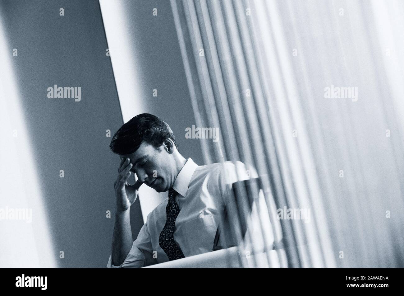 Polapan film image of an Executive in his office with a stress induced headache Stock Photo