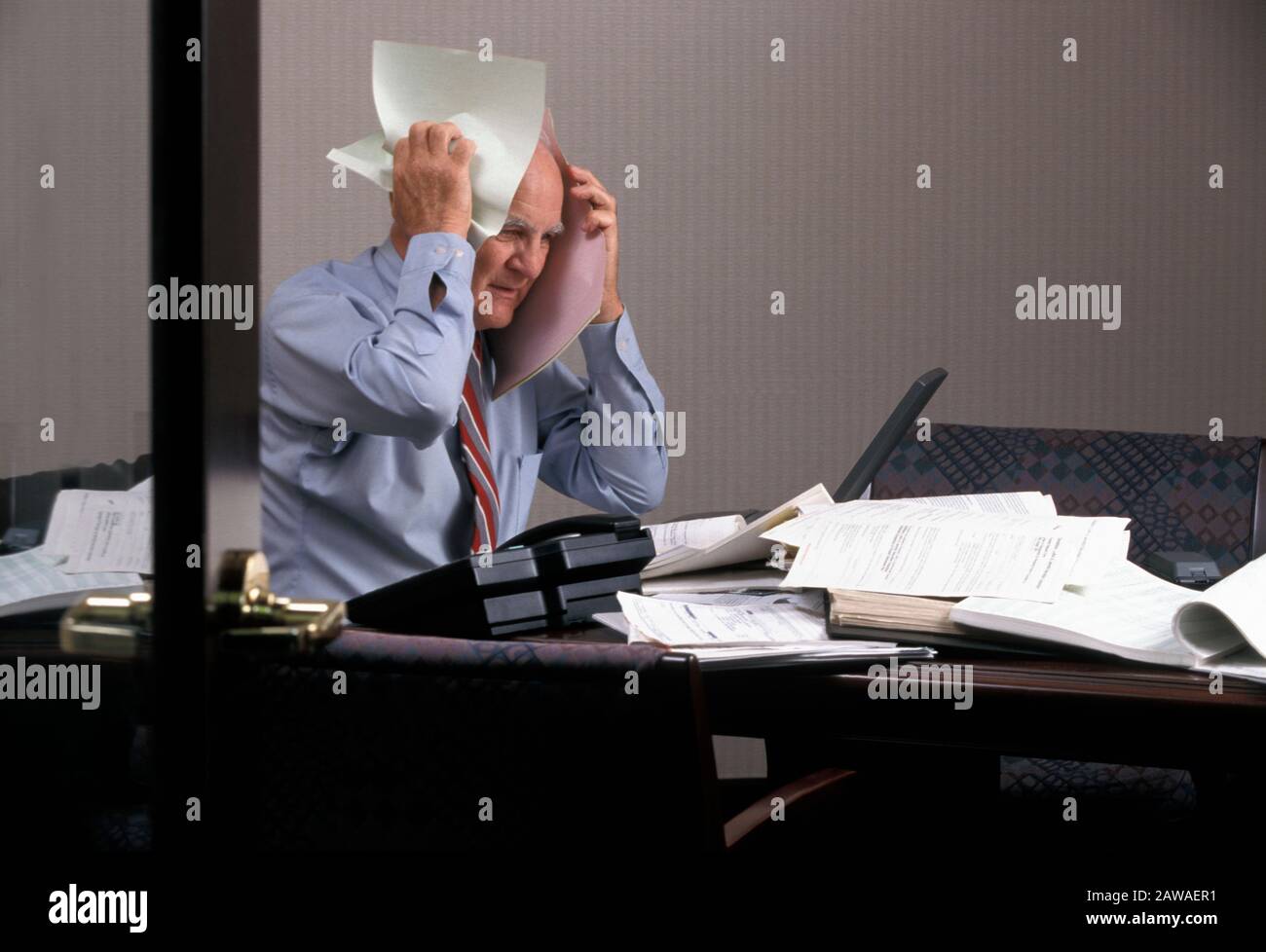 Stressed businessman with too much paperwork Stock Photo