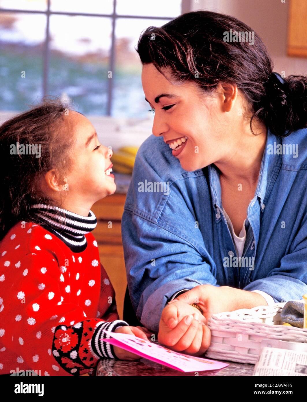 Latino mother and daughter laughing in their home Stock Photo - Alamy