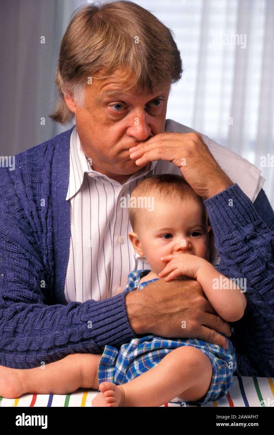 Grandfather Mimicking Baby's Face in Mirror Stock Photo