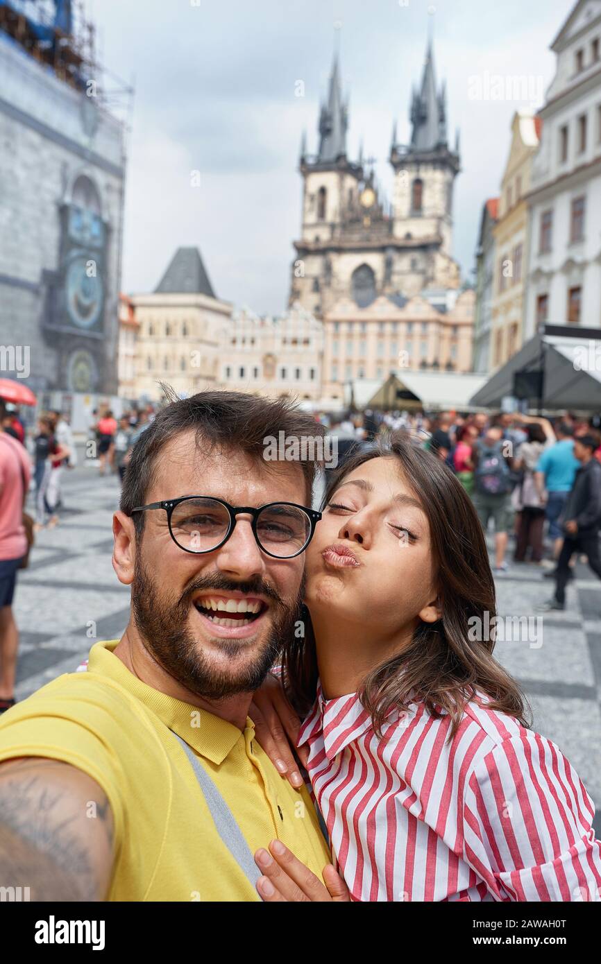 Happy man and woman walking in city streets on vacation tourism and making selfie. Stock Photo