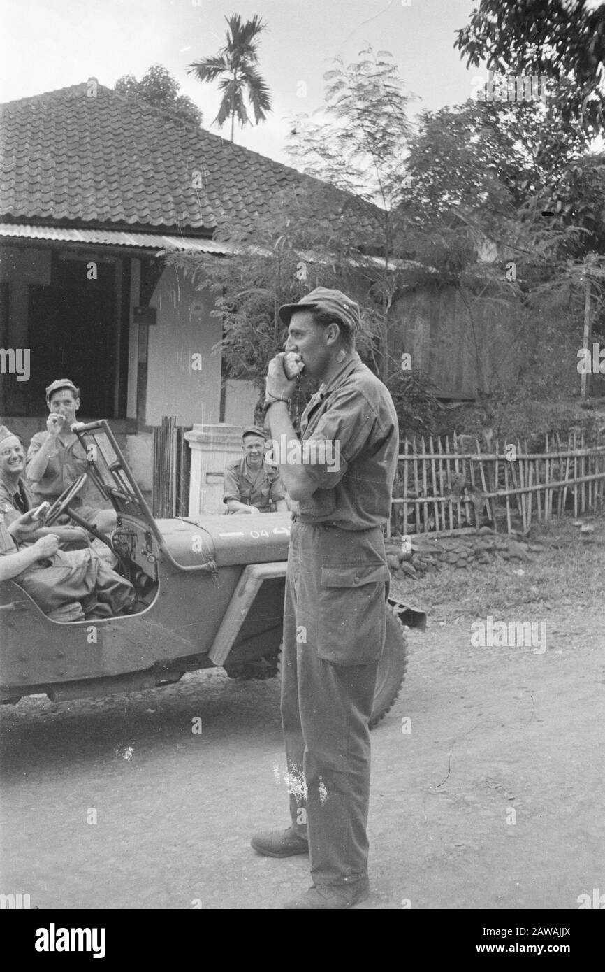 Action Buitenzorg July 24, 1947  [Military eat bread. Other soldiers watch] Date: July 24, 1947 Location: Indonesia, Java, Dutch East Indies Stock Photo