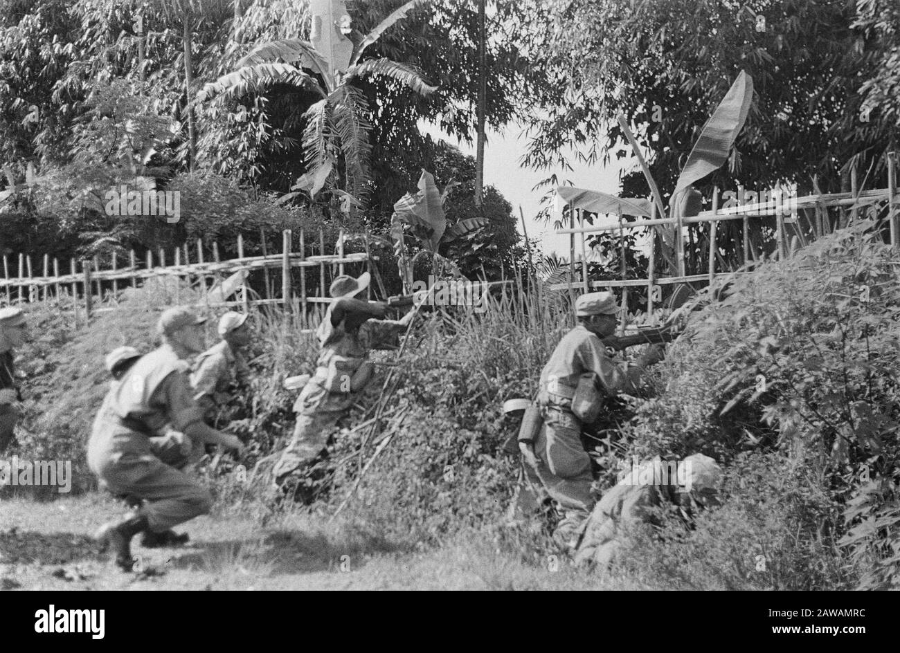 Photoreportage near Buitenzorg  Soldiers in battle position along the roadside Date: January 1947 Location: Bogor, Indonesia, Java, Dutch East Indies Stock Photo