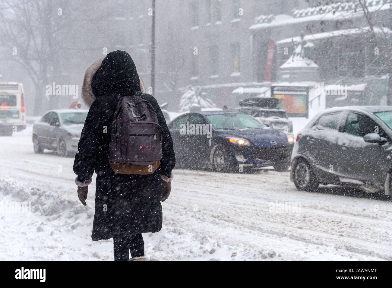 Montreal, CA - 7 February 2020: Woman walking in Downtown Montreal during snow storm. Stock Photo