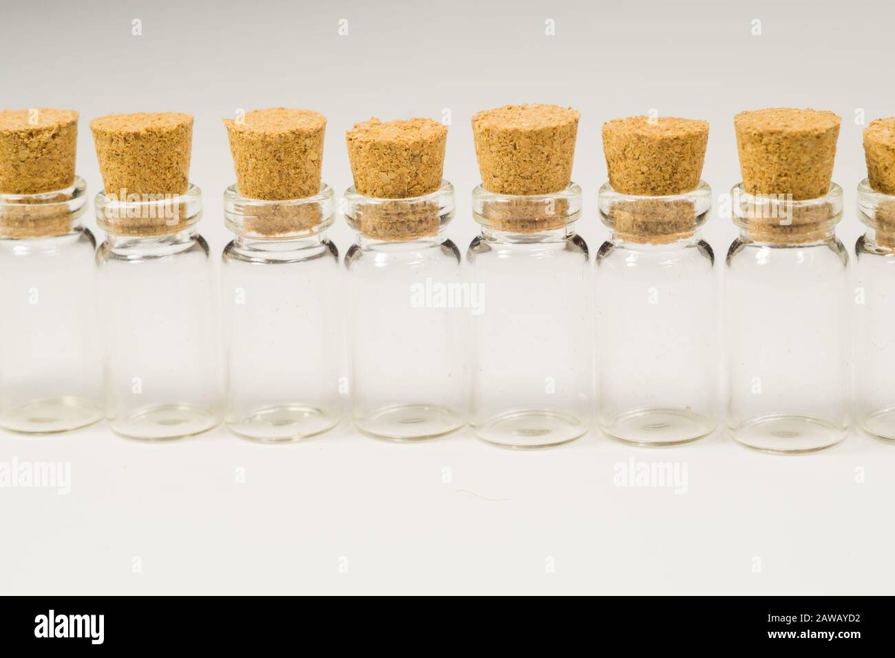 Empty little bottles with cork stopper isolated on white. glass vessels