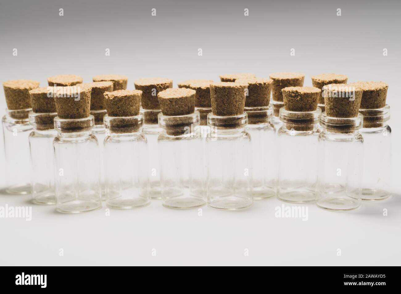 Empty little bottles with cork stopper isolated on white. glass vessels