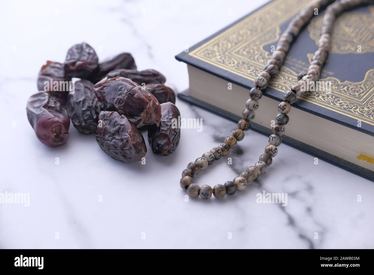 Close up of date fruit and quran on table Stock Photo