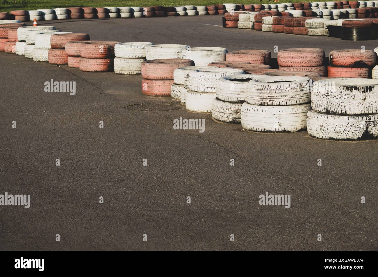Race track safety barrier. asphalt racing track with red and white tires. colorful tires stack