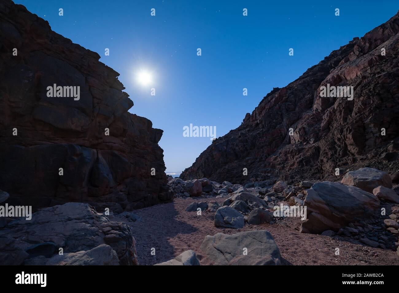 Night landscape with majestic mountains, moon and stars in sky, long exposure. Mountaineering and climb background Stock Photo