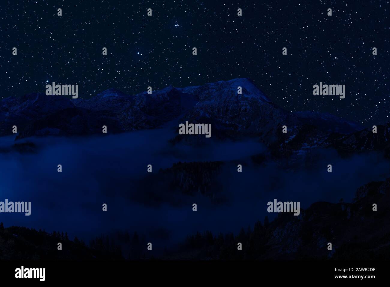 Night landscape with majestic mountains and stars in sky, mountaineering and climb background Stock Photo