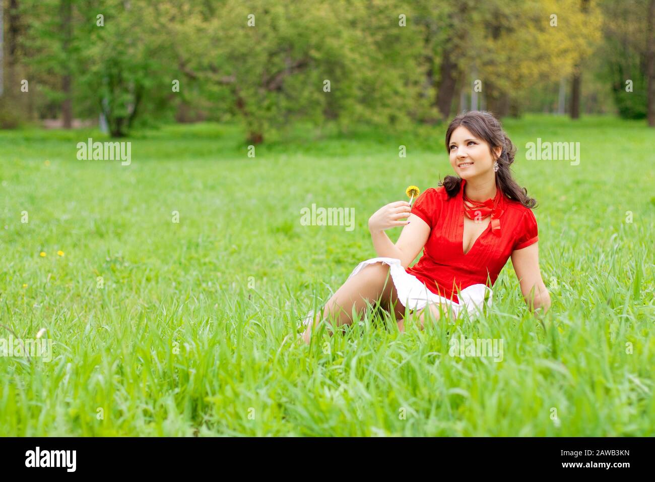 Picture of beautiful girl sitting on the grass in the park Stock Photo ...